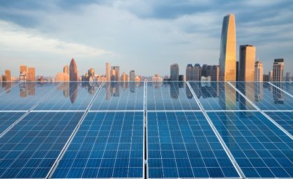 Solar panels with cityscape in the background.